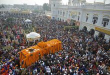 Sikh devotees gather around a bus carrying the Guru Granth Sahib (Sikh holy book) during a religious procession on the occasion of the birth anniversary of Guru Nanak Dev, the founder of Sikhism, in Nankana Sahib on November 19